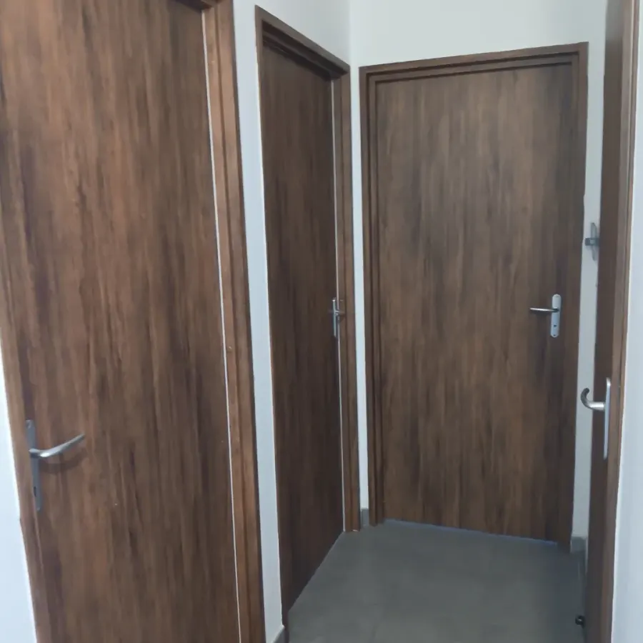 Couloir aux portes recouvertes d'un vinyle effet bois